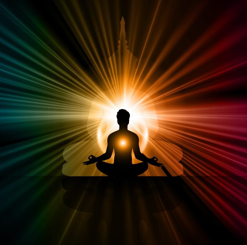 A seated meditator silhouetted against radiating light